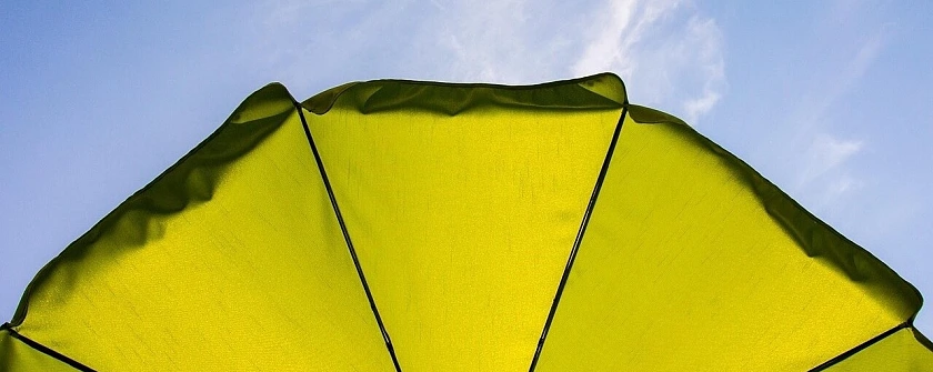 Gelber Sonnenschirm vor blauem Himmel