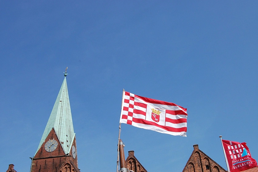 Tower of the Church of Our Lady and flag of the Free Hanseatic City of Bremen.