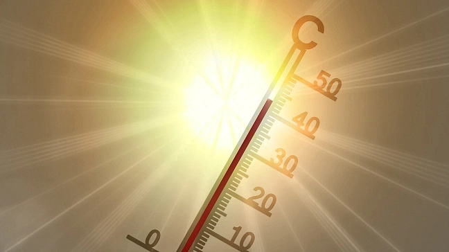 Thermometer reading over 40 degrees Celsius in front of a strong sun.